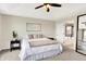 A bright main bedroom features a tray ceiling, ceiling fan, and an ensuite bath and tub at 14499 Milton Rd, Fishers, IN 46037