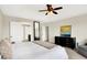 A bright main bedroom features a tray ceiling, ceiling fan, and a sitting area by the windows at 14499 Milton Rd, Fishers, IN 46037