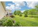 Lush backyard featuring a green lawn, mature trees, flowering plants, and a charming deck at 1468 Blackthorne N Trl, Plainfield, IN 46168