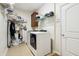 Bright laundry room with a modern white washer and dryer, storage shelves, and tile floor at 1468 Blackthorne N Trl, Plainfield, IN 46168