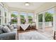 Sunroom filled with natural light, featuring a cozy couch, large windows, and access to the deck at 1468 Blackthorne N Trl, Plainfield, IN 46168