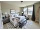 A stylish bedroom featuring a king bed, bench, decorative rug, and cozy reading chair at 17399 Dovehouse Ln, Westfield, IN 46074