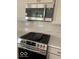Stainless steel microwave and gas range cooktop set against a gray tiled backsplash at 17399 Dovehouse Ln, Westfield, IN 46074