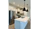 Modern kitchen features stainless steel appliances, a large island, shaker cabinets, and pendant lighting at 17399 Dovehouse Ln, Westfield, IN 46074
