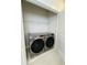A conveniently located laundry area featuring modern, front load, Samsung washer and dryer with overhead shelving at 17399 Dovehouse Ln, Westfield, IN 46074