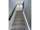 Carpeted staircase with dark wood railing leading to the second floor at 17399 Dovehouse Ln, Westfield, IN 46074