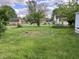 Spacious backyard featuring lush green grass and surrounding trees at 207 E Plum St, Anderson, IN 46012