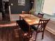 Cozy dining room with wood floors, dark accent wall, and seating for four at 207 E Plum St, Anderson, IN 46012