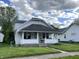 Charming home exterior with covered front porch and well maintained lawn at 207 E Plum St, Anderson, IN 46012