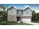 Charming two-story home with brick and gray siding, a front-entry garage, and well-manicured landscaping at 2124 Foothill Dr, Greenfield, IN 46140