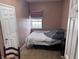 Bedroom with tan walls, large window, a bed with white and gray sheets, and a light wood door at 2208 S F St, Elwood, IN 46036