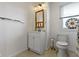 Updated bathroom with white vanity, tiled floors, ornate mirror and a toilet with colorful window at 236 W 33Rd St, Indianapolis, IN 46208