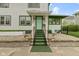 Inviting front porch with potted plants, green-carpeted steps, and an accent chair at 236 W 33Rd St, Indianapolis, IN 46208
