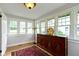 Bright sunroom with multiple windows, hardwood floors, and a vintage cabinet at 236 W 33Rd St, Indianapolis, IN 46208