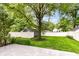Lush backyard featuring a mature tree, green grass, and a white fence at 2526 Dell Zell Dr, Indianapolis, IN 46220