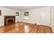 Cozy living room featuring hardwood floors, a brick fireplace, and large windows at 2526 Dell Zell Dr, Indianapolis, IN 46220