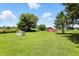 Picturesque backyard featuring a well-maintained lawn, mature trees, and a classic red barn at 25420 Jerkwater Rd, Sheridan, IN 46069