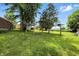 Spacious backyard featuring a yellow swing set and mature trees for outdoor enjoyment and relaxation at 25420 Jerkwater Rd, Sheridan, IN 46069