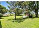 Expansive backyard with lush lawn, mature trees, utility shed, propane tank, and a charming red barn at 25420 Jerkwater Rd, Sheridan, IN 46069