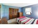 Cozy bedroom with blue walls, wood closet and dresser, and bright natural light from the window at 25420 Jerkwater Rd, Sheridan, IN 46069