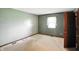 Empty bedroom with gray-green walls, a window, carpet, and an open doorway at 25420 Jerkwater Rd, Sheridan, IN 46069