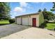 Detached two-car garage with white doors, red entry door, and concrete driveway at 25420 Jerkwater Rd, Sheridan, IN 46069