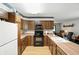 Functional kitchen with wood cabinets, laminate countertops, black appliances, and light hardwood floors at 25420 Jerkwater Rd, Sheridan, IN 46069
