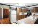 Well-maintained kitchen featuring wood cabinetry, appliances, and a view of hardwood floor in the adjacent room at 25420 Jerkwater Rd, Sheridan, IN 46069
