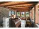 Enclosed sunroom with exposed wood ceiling, brick wall, and views of the lush yard at 25420 Jerkwater Rd, Sheridan, IN 46069