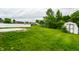 View of the large backyard with a new patio, a storage shed, and a well-manicured lawn at 321 Virginia St, Fortville, IN 46040
