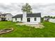 A fire pit sits next to the luscious lawn and new patio of this property at 321 Virginia St, Fortville, IN 46040