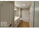 Bathroom with white vanity, tub with shower, and light wood-look flooring at 321 Virginia St, Fortville, IN 46040