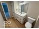 Bright bathroom featuring a white vanity, large mirror, modern lighting, and neutral walls at 321 Virginia St, Fortville, IN 46040