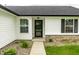The entryway features a stylish black door and black shutters. A small stone garden bed adds to the curb appeal at 321 Virginia St, Fortville, IN 46040