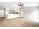 Open-concept living room features wood floors, fan, and modern pendant lights over a kitchen bar at 321 Virginia St, Fortville, IN 46040
