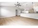 Open-concept living room with light wood floors and modern pendant lighting over the kitchen bar at 321 Virginia St, Fortville, IN 46040