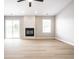 Spacious living room with light wood floors, a modern fireplace, and sliding glass doors at 321 Virginia St, Fortville, IN 46040