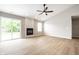 Living room with light wood floors, fireplace, sliding glass doors, and a ceiling fan at 321 Virginia St, Fortville, IN 46040