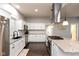 Modern kitchen with white cabinets, granite countertops, a stainless steel range hood, and sleek appliances at 326 Parkway Ave, Indianapolis, IN 46225