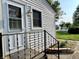 Quaint front porch with black metal railing, light fixture, and a view of the neighborhood at 3321 Sycamore Dr, Columbus, IN 47203