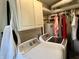 Bright laundry features cabinets, a water heater, a clothing rack, and modern washer/dryer at 3321 Sycamore Dr, Columbus, IN 47203