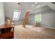 Spacious attic area with wooden ladder, sky light, sitting chair, ceiling fan, and neutral carpet at 4013 Hillendale Dr, Greenwood, IN 46142