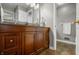 Double sink bathroom vanity featuring wood cabinets, framed mirrors, and neutral tile flooring at 4013 Hillendale Dr, Greenwood, IN 46142