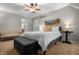Serene bedroom featuring a queen bed, gray storage bench, ceiling fan, and stylish decor at 4013 Hillendale Dr, Greenwood, IN 46142