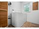 Bright laundry room with white shiplap walls, window view, and modern washer and dryer at 4013 Hillendale Dr, Greenwood, IN 46142