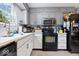 A bright kitchen featuring white cabinets, black appliances, plenty of storage and a window above the sink at 4016 Dogwood Ln, Franklin, IN 46131