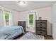 Comfortable bedroom with plenty of natural light, wood floors, and ample storage in dressers and closets at 426 Tipton Ln, Columbus, IN 47201