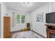 Cozy bedroom featuring wood-paneled walls, hardwood floors, and a bright window overlooking the yard at 426 Tipton Ln, Columbus, IN 47201