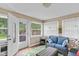 Bright sunroom featuring a comfortable seating area and a view of the private backyard and hot tub at 426 Tipton Ln, Columbus, IN 47201