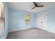 Light-filled bedroom features blue walls, carpet, closet, and a ceiling fan for comfort at 4605 S 150 W, Columbus, IN 47201